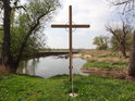 Soutok Dyje s Kyjovkou a kříž jako připomínka tragické události ze 4. srpna 1956, v pozadí kostel v Rabensburgu.